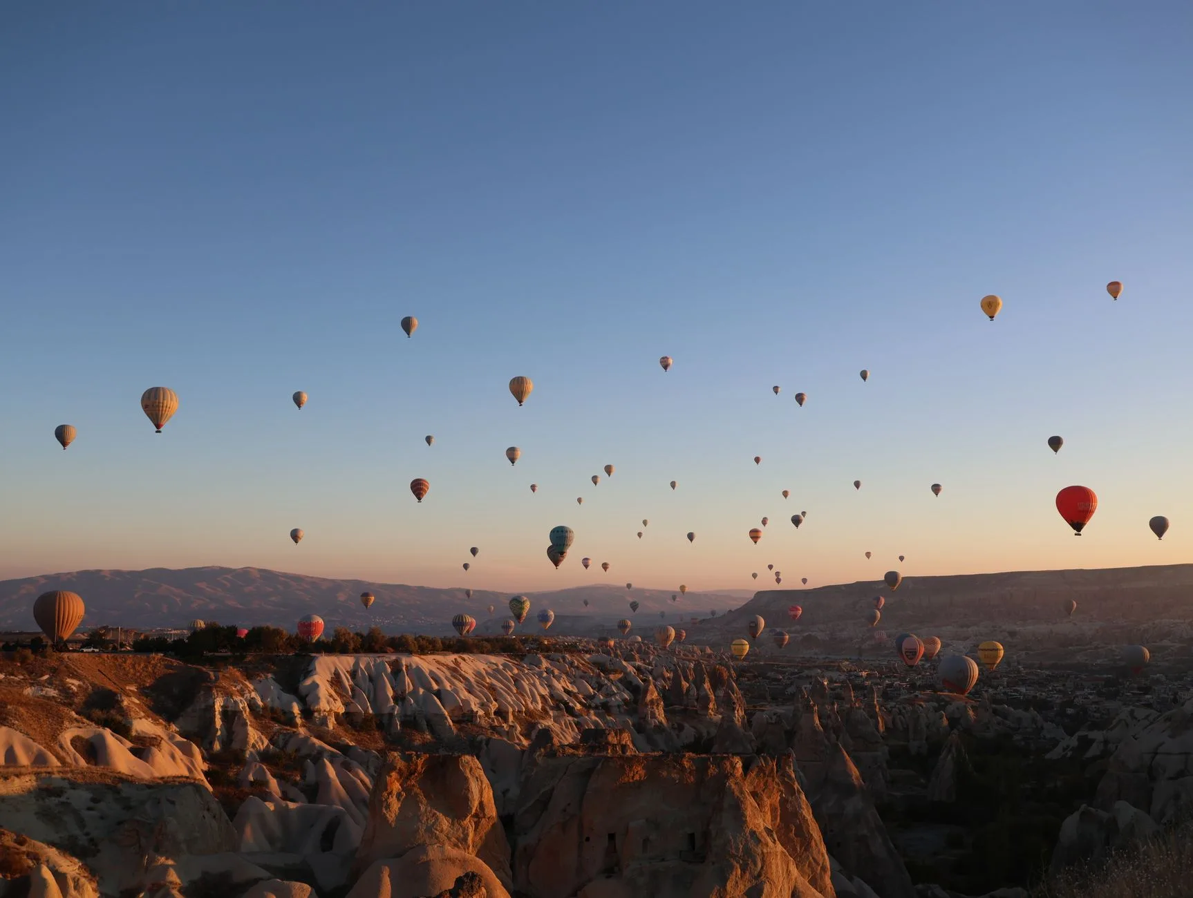 Montgolfières au lever du soleil au-dessus des cheminées de fée de Cappadoce